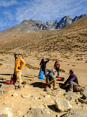 A group of trekkers resting on the trail during Kailash Parvat Yatra 2026, with the Himalayan mountains in the background.