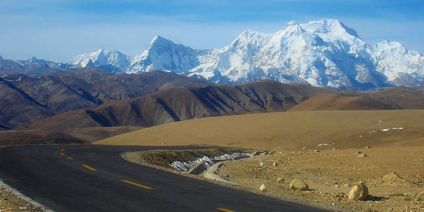 Snow-capped Meru Parvat at night with a full moon and stars shining above