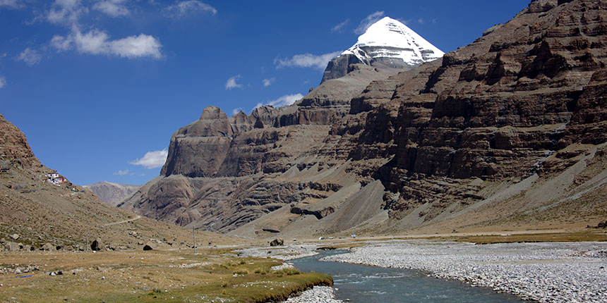 Snow-capped Mount Kailash peak with blue sky and river valley in Tibet, a sacred site for pilgrims of Kailash Mansarovar Yatra